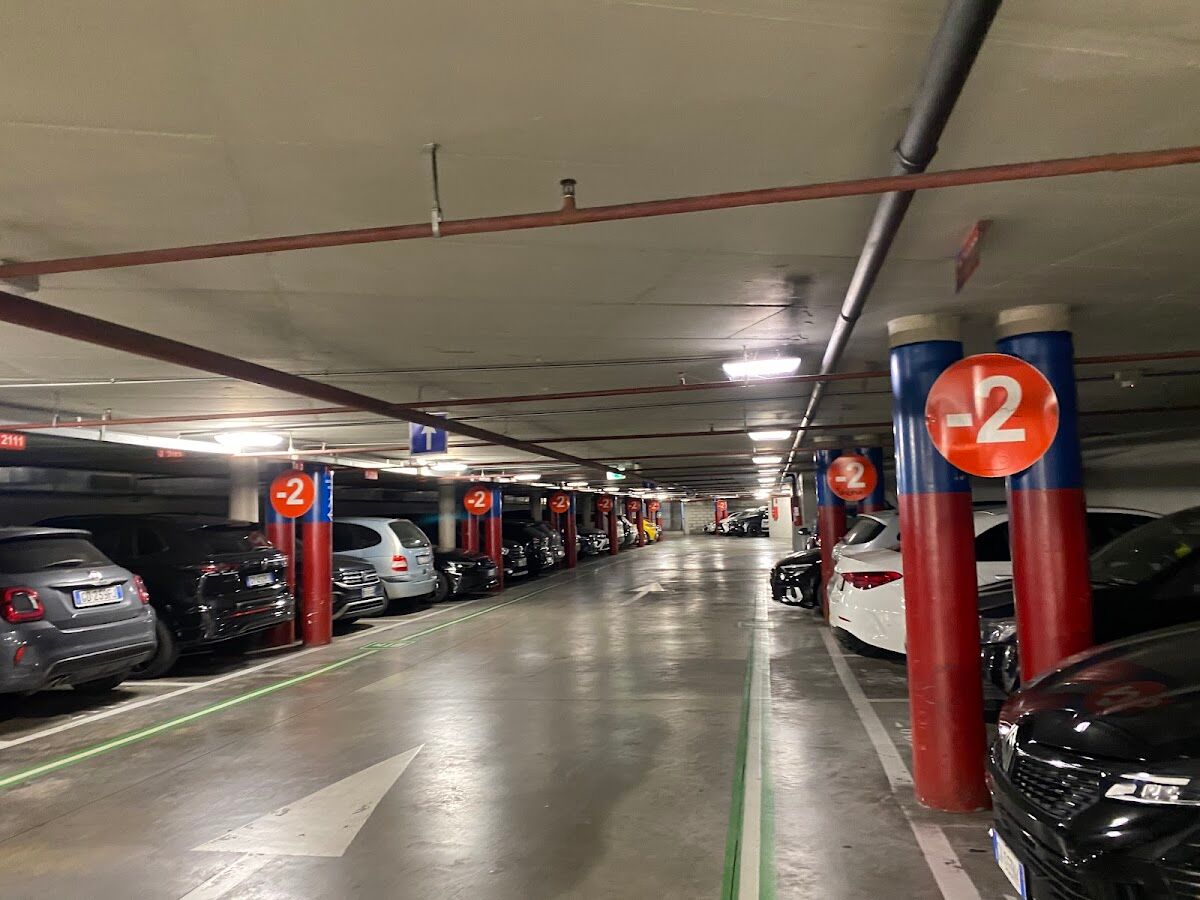 Parcheggio Beccaria: covered underground level (-2) with parked cars and red/blue numbered columns