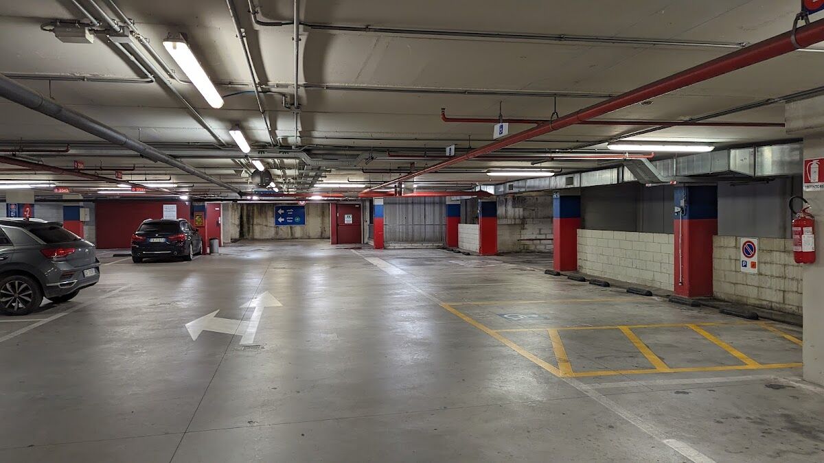 Parcheggio Stazione Fortezza Fiera: covered parking level with marked bays, directional arrows and accessible spaces