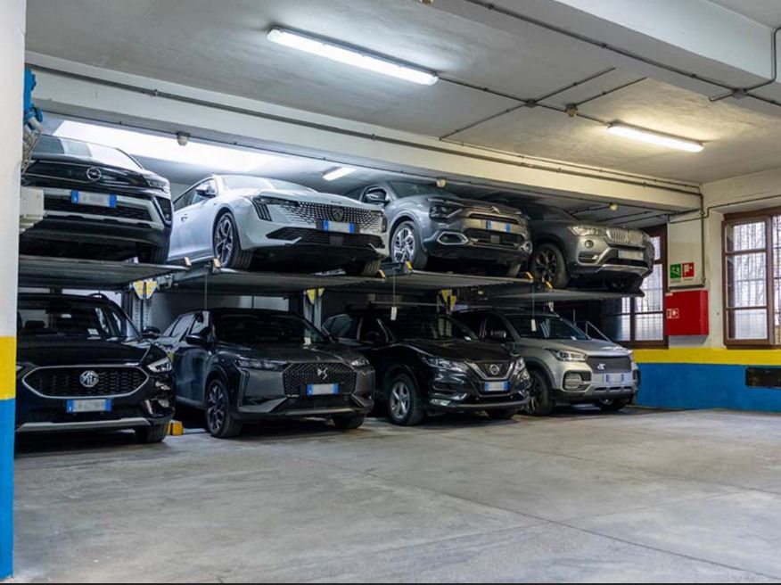 Cars stacked on a two-tier mechanical lift inside the covered Garage S. Antonino, Florence