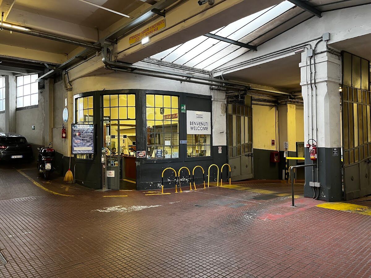 Interparking Garage Europa: covered ground-floor entrance hall with WELCOME desk and parked motorcycle