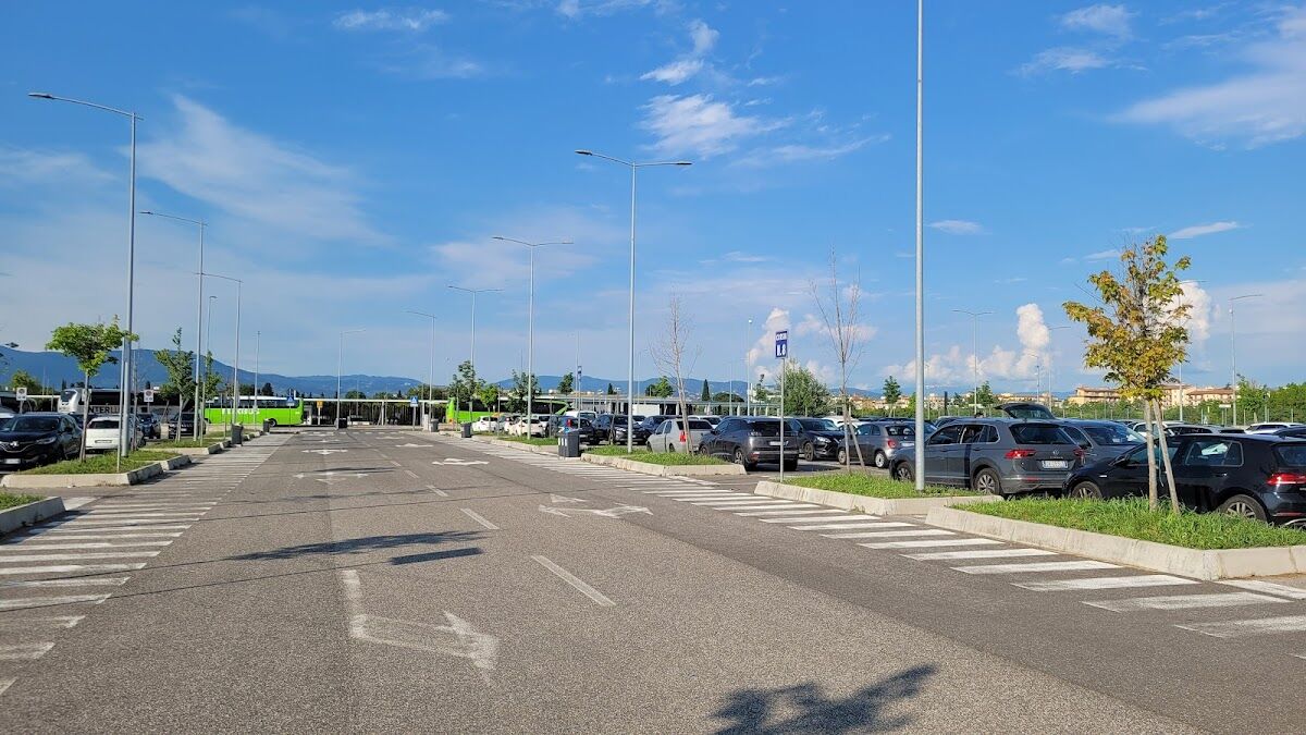 Park & Ride Villa Costanza: open-air car park lot with parked cars and tram/bus stop beyond